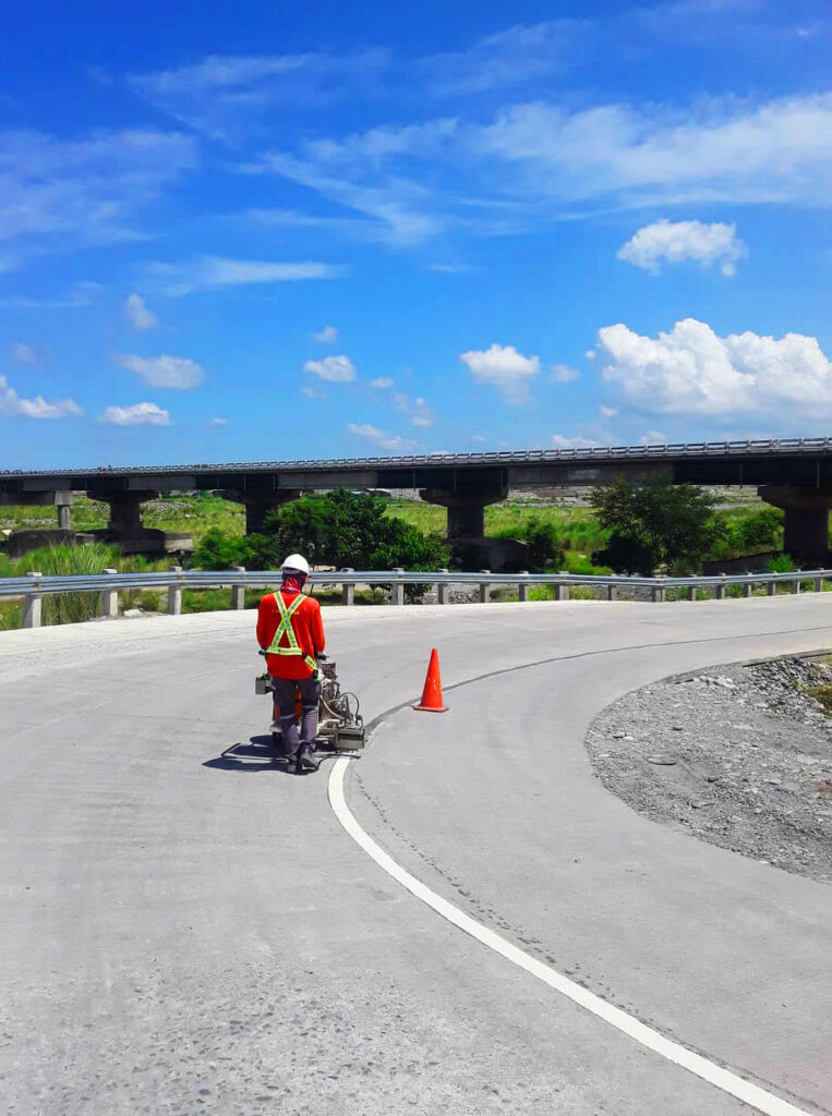 Contractor applying white road paint