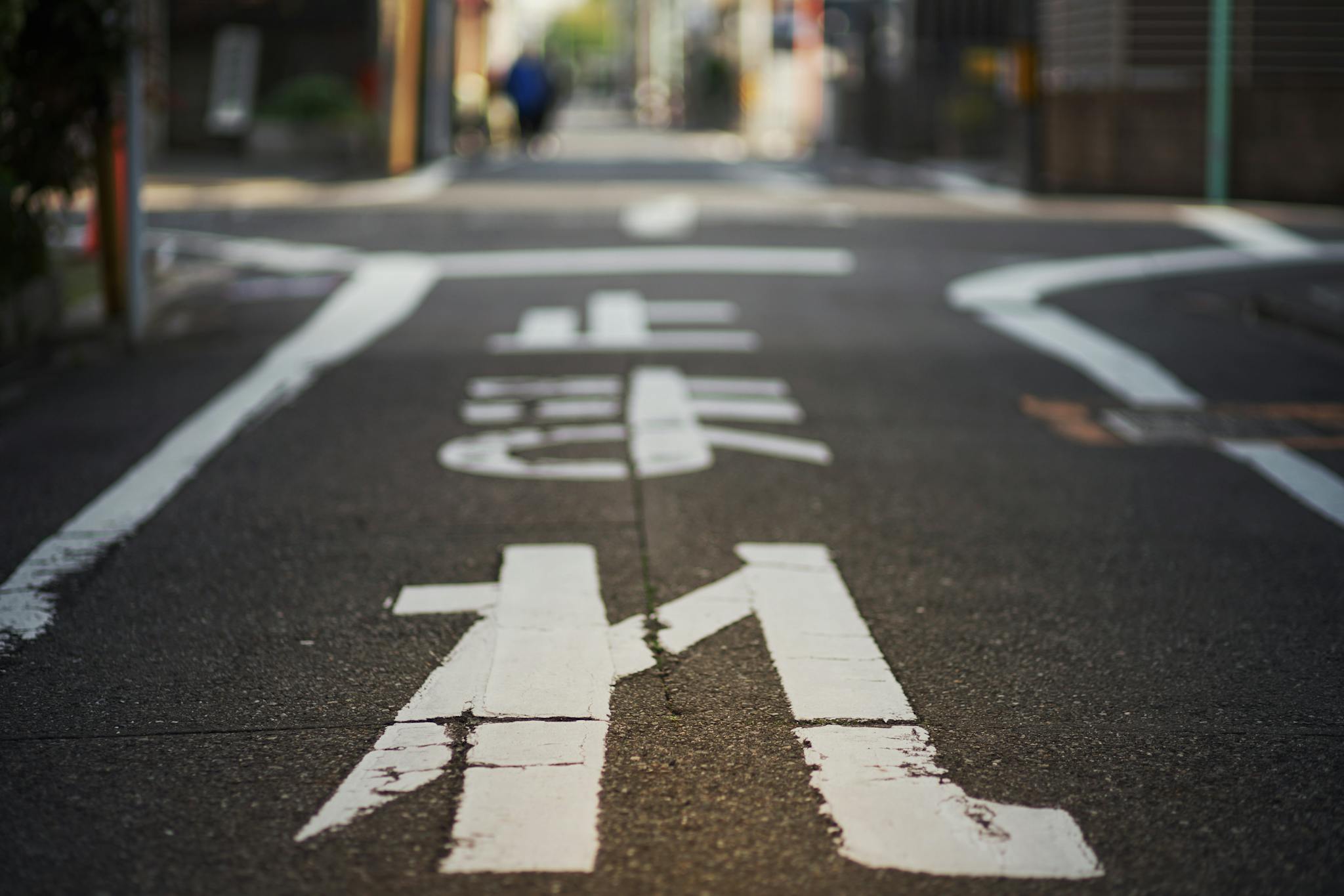 A close-up view of a Japanese city street with white painted markings in Nagoya, Japan.