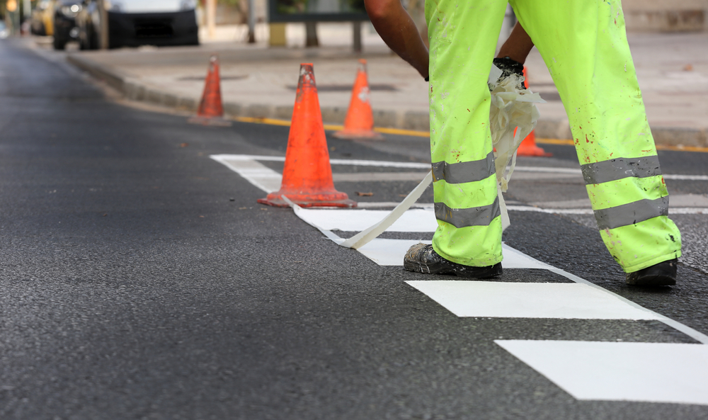 a safety road officer painting a pedestrian lane