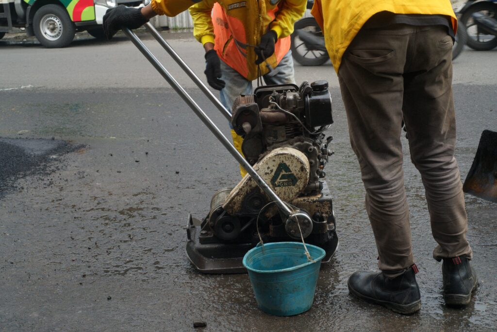 a worker is checking an asphalt compactor machine in Bandung, Indonesia
