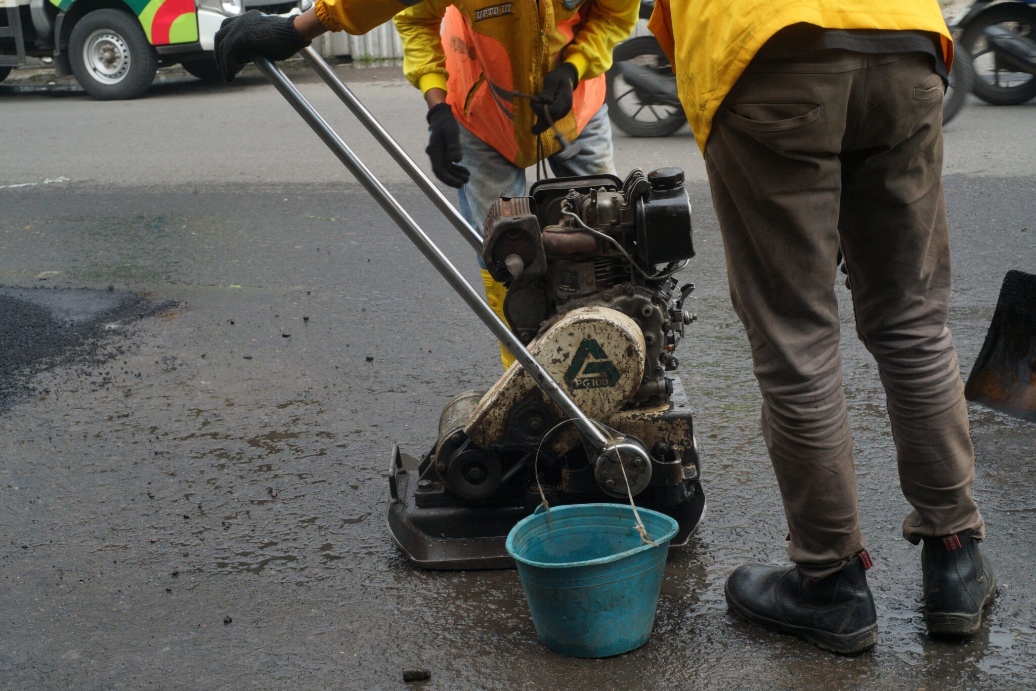 a worker is checking an asphalt compactor machine in Bandung, Indonesia